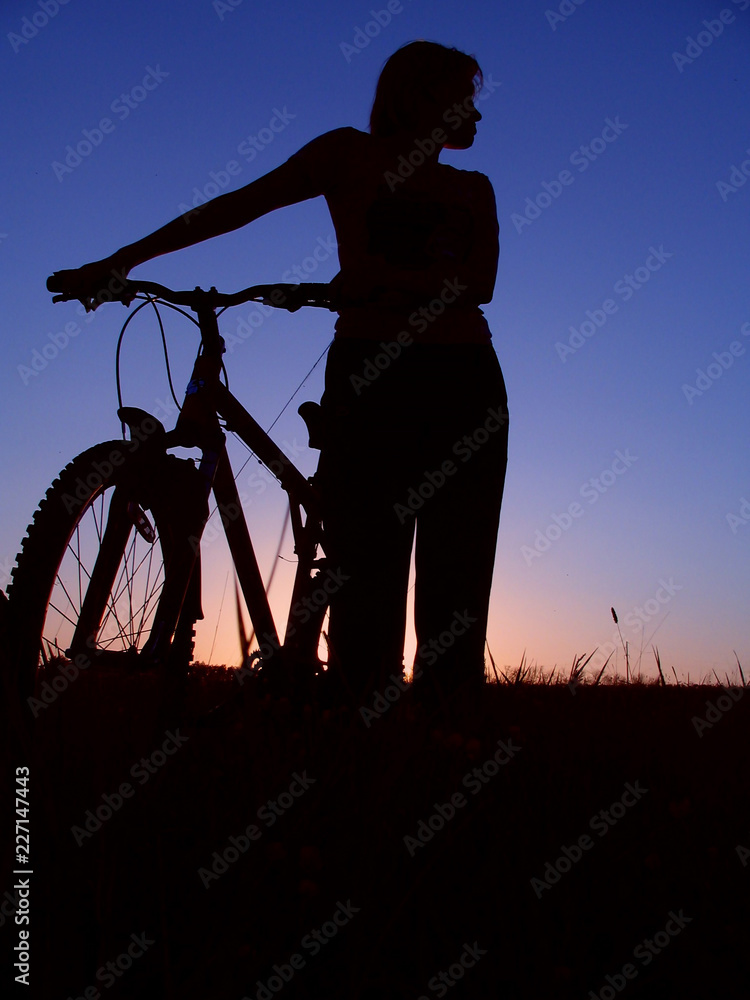 Obraz premium Girl silhouette of the cyclist riding