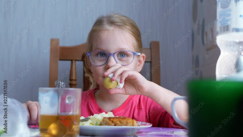 Little beautiful cute girl eating a boiled egg at the table in the kitchen Little beautiful cute girl eating a boiled egg at the table in the kitchen