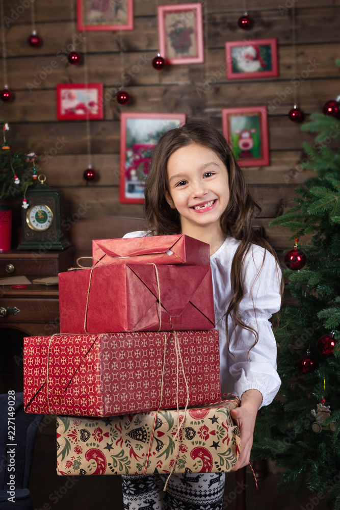 Happy smiling little girl 7 years old holds christmas gifts. Boxes decorated for christmas Happy smiling little girl 7 years old holds christmas gifts. Boxes decorated for christmas
