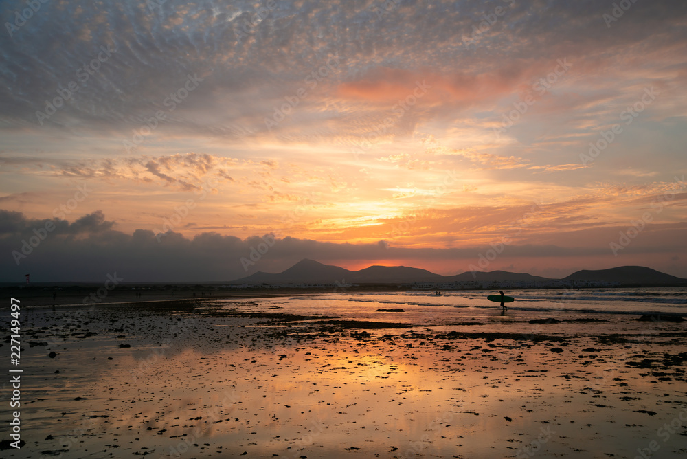 Fototapeta premium Amazing sunset with pockmarked sky shot on a sandy beach at low tide