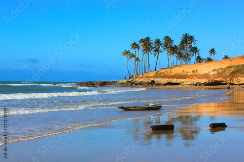 Lagoinha Beach, Ceará: palm trees, rocks, red sand hill, boat, logs, people, waves, reflection