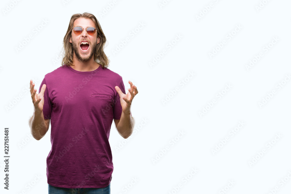Young handsome man with long hair wearing sunglasses over isolated background crazy and mad shouting and yelling with aggressive expression and arms raised. Frustration concept. Young handsome man with long hair wearing sunglasses over isolated background crazy and mad shouting and yelling with aggressive expression and arms raised. Frustration concept.