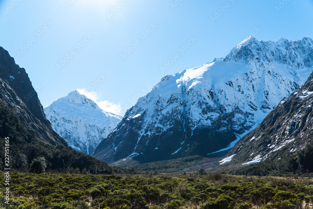huge mountains covered with snow in New Zealand on the road to Milford Sound