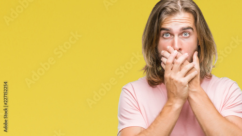 Young handsome man with long hair over isolated background shocked covering mouth with hands for mistake. Secret concept.