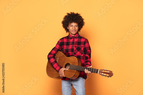 African teenage boy posing with guitar.