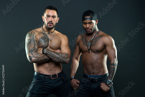 Tattoo is cool. Brutal macho style. Muscular men with fashionable tattoo style. Sexy men with muscular torso. We feel sexy