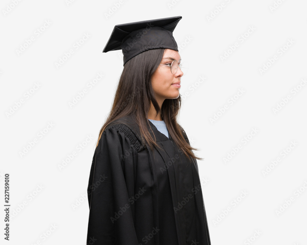 Young hispanic woman wearing graduated cap and uniform looking to side, relax profile pose with natural face with confident smile. Young hispanic woman wearing graduated cap and uniform looking to side, relax profile pose with natural face with confident smile.