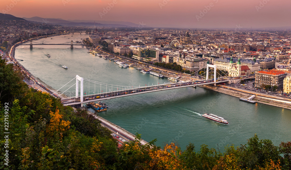 Obraz premium Budapest, Hungary - Aerial panoramic skyline of Budapest at sunset with Elisabeth Bridge (Erzsebet Hid), Szechenyi Chain Bridge, Parliament and sightseeing boat on River Danube