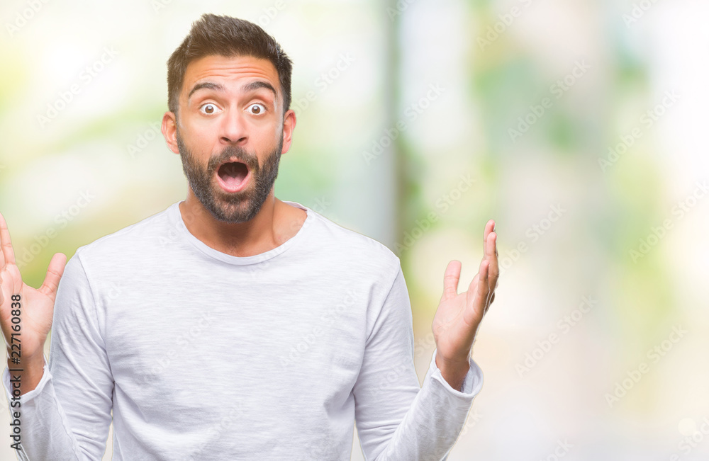 Adult hispanic man over isolated background celebrating crazy and amazed for success with arms raised and open eyes screaming excited. Winner concept Adult hispanic man over isolated background celebrating crazy and amazed for success with arms raised and open eyes screaming excited. Winner concept