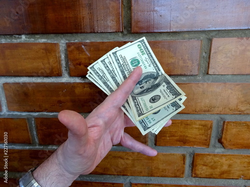 Hundred dollars cash in men's hand photo