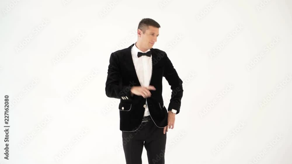 humorist in trendy costume is parodying a man who dancing in a club on a white background in the studio