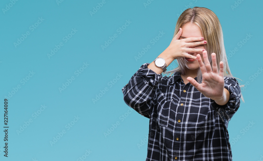 Young blonde woman over isolated background covering eyes with hands and doing stop gesture with sad and fear expression. Embarrassed and negative concept. Young blonde woman over isolated background covering eyes with hands and doing stop gesture with sad and fear expression. Embarrassed and negative concept.