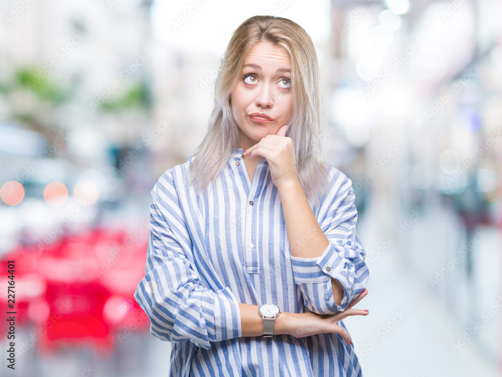 Fototapeta premium Young blonde woman over isolated background with hand on chin thinking about question, pensive expression. Smiling with thoughtful face. Doubt concept.