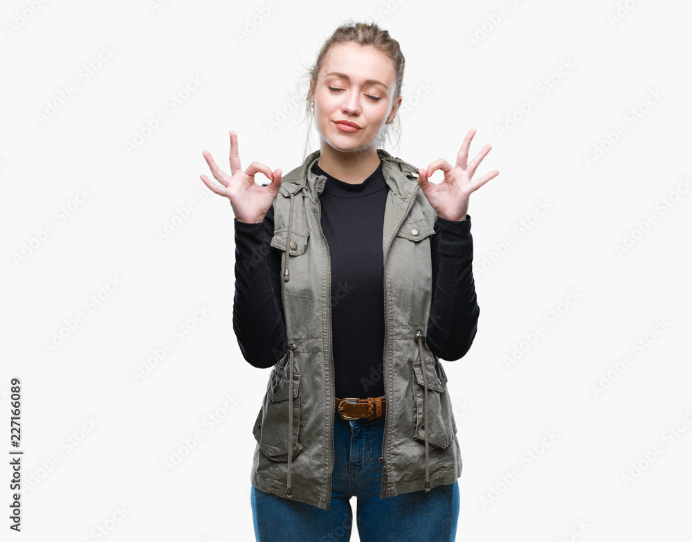 Young blonde woman over isolated background relax and smiling with eyes closed doing meditation gesture with fingers. Yoga concept. Young blonde woman over isolated background relax and smiling with eyes closed doing meditation gesture with fingers. Yoga concept.