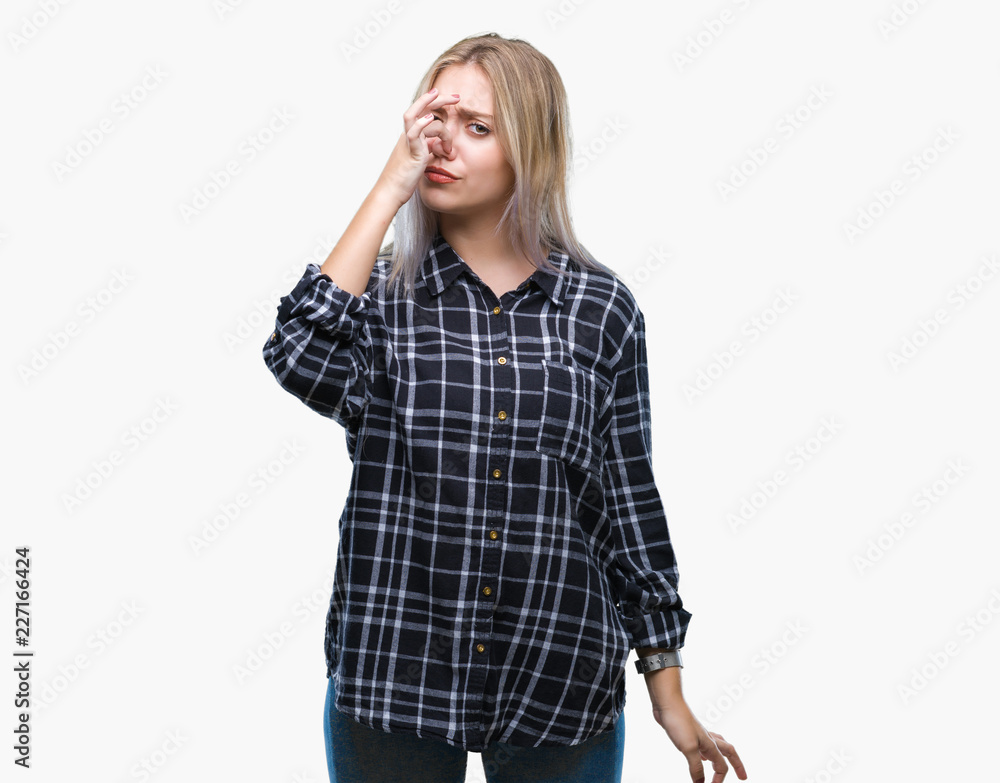 Young blonde woman over isolated background smelling something stinky and disgusting, intolerable smell, holding breath with fingers on nose. Bad smells concept. Young blonde woman over isolated background smelling something stinky and disgusting, intolerable smell, holding breath with fingers on nose. Bad smells concept.