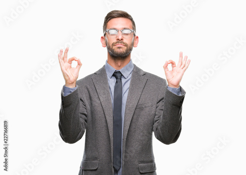 Young handsome business man over isolated background relax and smiling with eyes closed doing meditation gesture with fingers. Yoga concept.