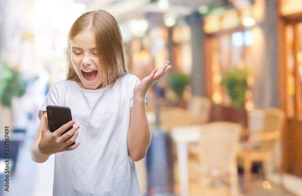 Young beautiful girl sending message texting using smarpthone over isolated background very happy and excited, winner expression celebrating victory screaming with big smile and raised hands