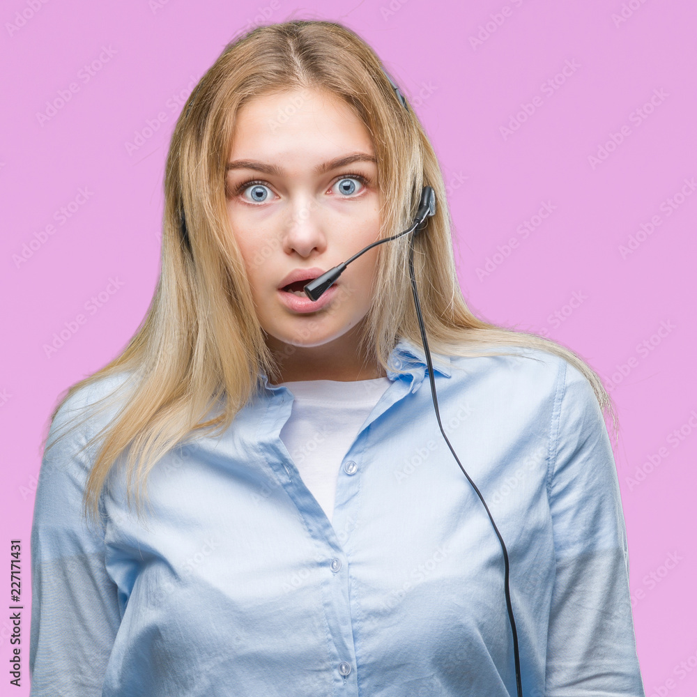Young caucasian business woman wearing call center headset over isolated background afraid and shocked with surprise expression, fear and excited face. Young caucasian business woman wearing call center headset over isolated background afraid and shocked with surprise expression, fear and excited face.