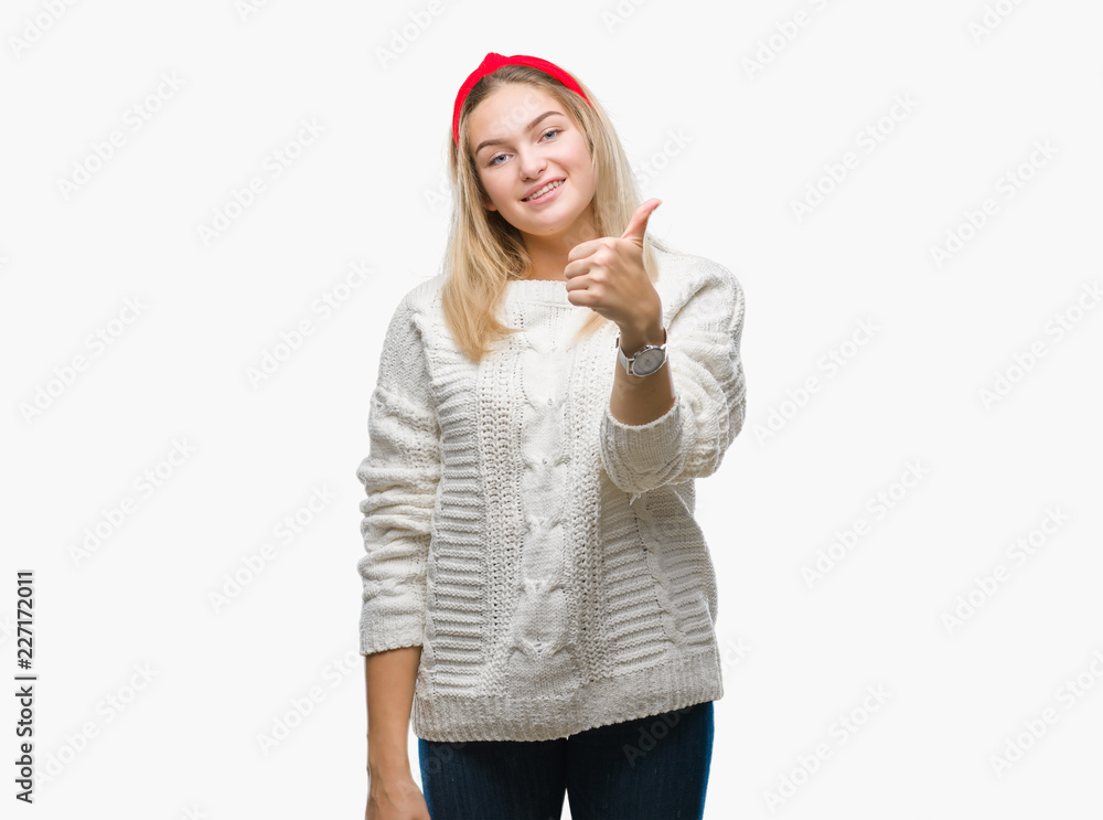 Young caucasian woman wearing winter sweater over isolated background doing happy thumbs up gesture with hand. Approving expression looking at the camera with showing success. Young caucasian woman wearing winter sweater over isolated background doing happy thumbs up gesture with hand. Approving expression looking at the camera with showing success.