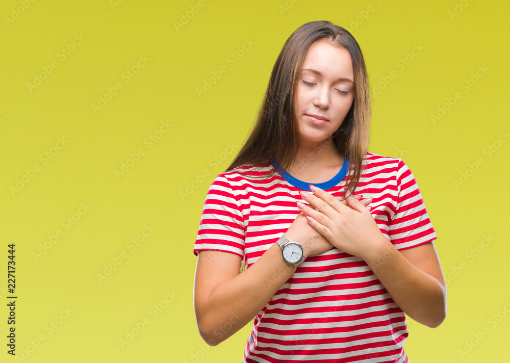 Young caucasian beautiful woman over isolated background smiling with hands on chest with closed eyes and grateful gesture on face. Health concept. Young caucasian beautiful woman over isolated background smiling with hands on chest with closed eyes and grateful gesture on face. Health concept.