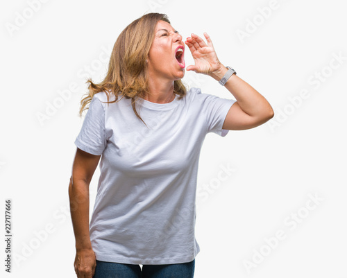 Middle age senior hispanic woman over isolated background shouting and screaming loud to side with hand on mouth. Communication concept.