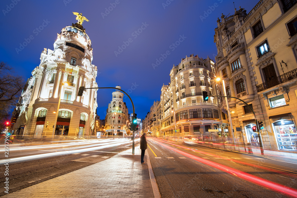 Car and traffic lights on Gran via street, main shopping street in Madrid at night. Spain, Europe. Lanmark in Madrid, Spain