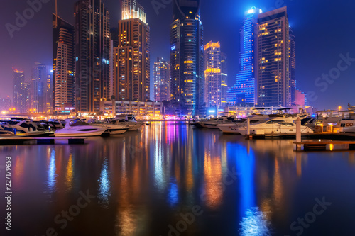 Beautiful view to Dubai Marina  UAE. Luxury yachts at pier. Long exposure time lapse effect at night