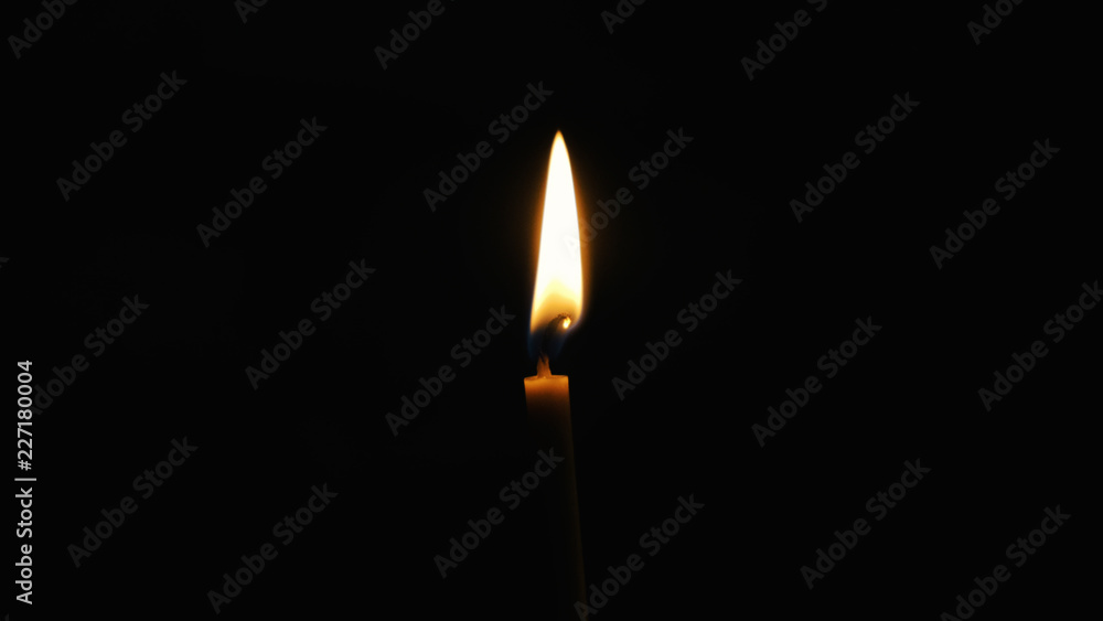 Flame on the wax candle burns and shines in the Orthodox ancient dark temple Flame on the wax candle burns and shines in the Orthodox ancient dark temple