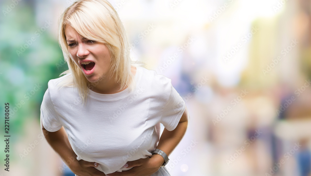 Young beautiful blonde woman wearing white t-shirt over isolated background with hand on stomach because indigestion, painful illness feeling unwell. Ache concept.