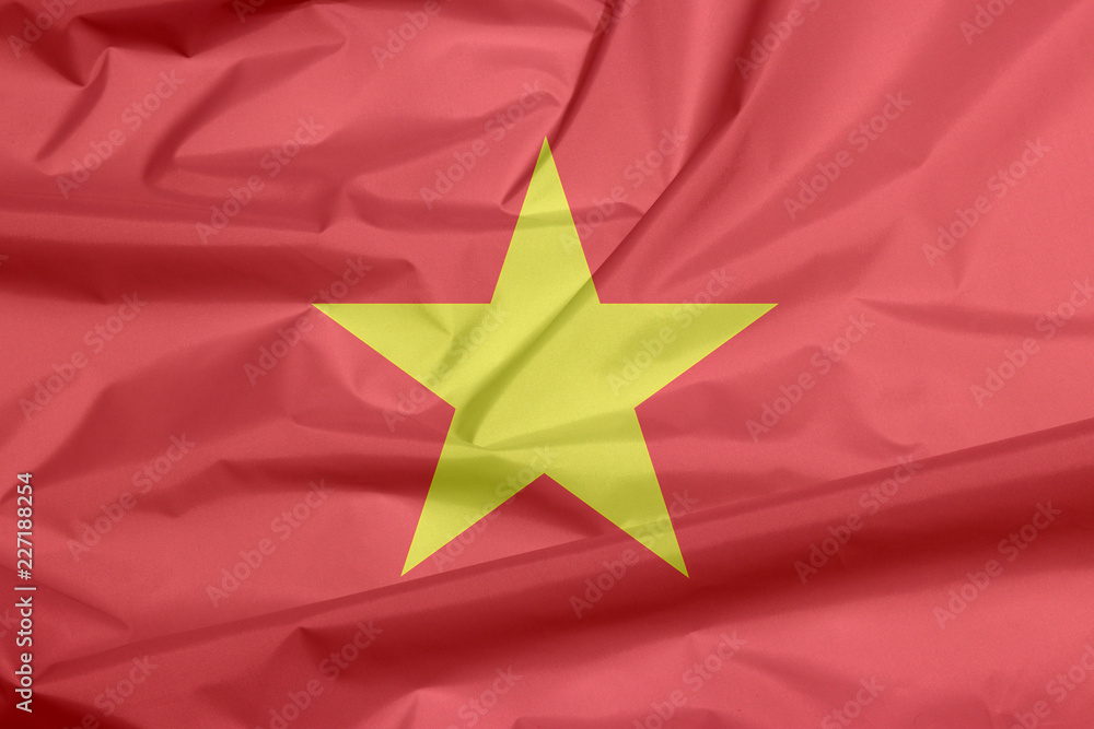 Fabric flag of Vietnam. Crease of Vietnamese flag background, yellow star on red flag. Fabric flag of Vietnam. Crease of Vietnamese flag background, yellow star on red flag.