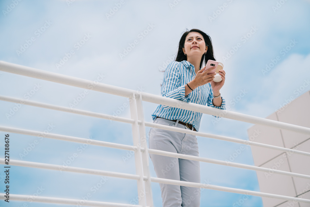 an elegant woman standing outdoor with a blue sky