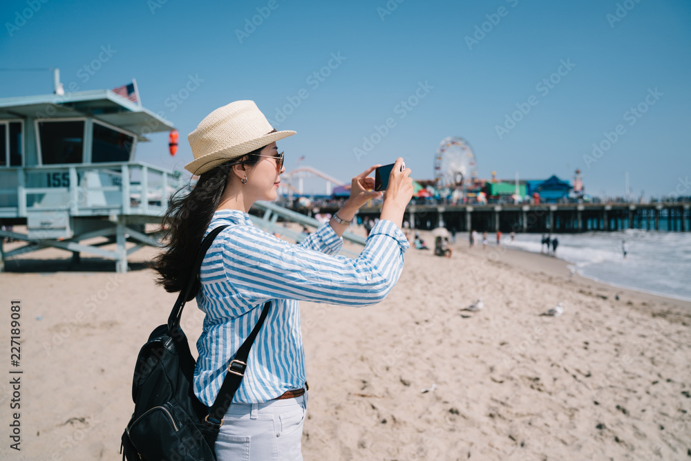 a pretty female tourist taking picture of beach
