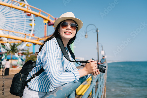 cheerful photographer taking photo of blue ocean