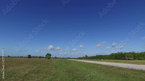 White Helicopter flies away in large open field on a sunny day photo