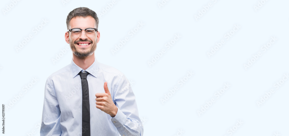 Young business man happy with big smile doing ok sign, thumb up with fingers, excellent sign Young business man happy with big smile doing ok sign, thumb up with fingers, excellent sign