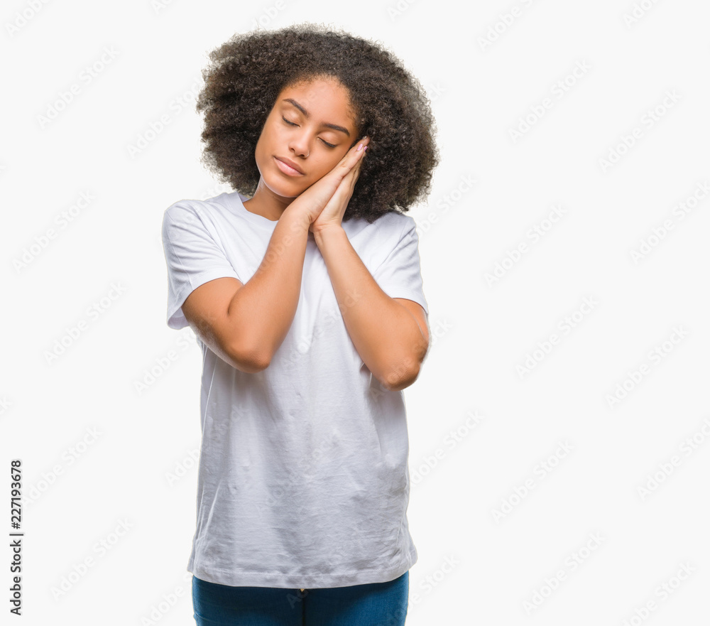 Young afro american woman over isolated background sleeping tired dreaming and posing with hands together while smiling with closed eyes. Young afro american woman over isolated background sleeping tired dreaming and posing with hands together while smiling with closed eyes.