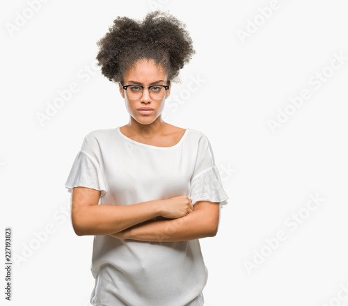 Young afro american woman wearing glasses over isolated background skeptic and nervous, disapproving expression on face with crossed arms. Negative person.