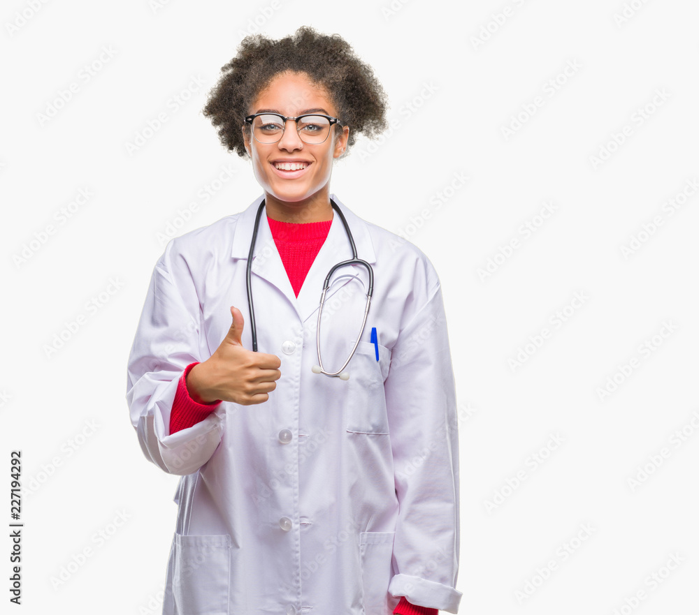 Young afro american doctor woman over isolated background doing happy thumbs up gesture with hand. Approving expression looking at the camera with showing success. Young afro american doctor woman over isolated background doing happy thumbs up gesture with hand. Approving expression looking at the camera with showing success.