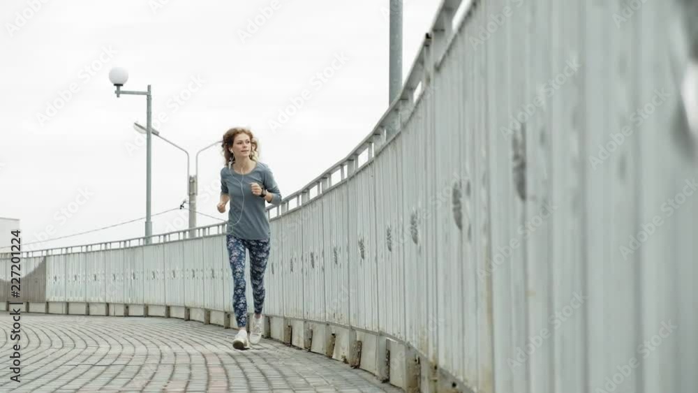 Young fitness woman having an exercise run in a residential area super slow motion Young fitness woman having an exercise run in a residential area super slow motion
