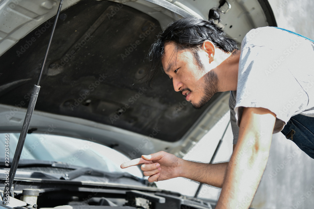 Car Repair Concept. Asian people are repairing cars on the roadside. Asian guy fixes car with confidence Car Repair Concept. Asian people are repairing cars on the roadside. Asian guy fixes car with confidence