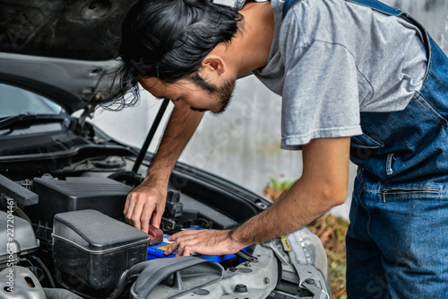 Car Repair Concept. Asian people are repairing cars on the roadside. Asian guy fixes car with confidence © S photographer