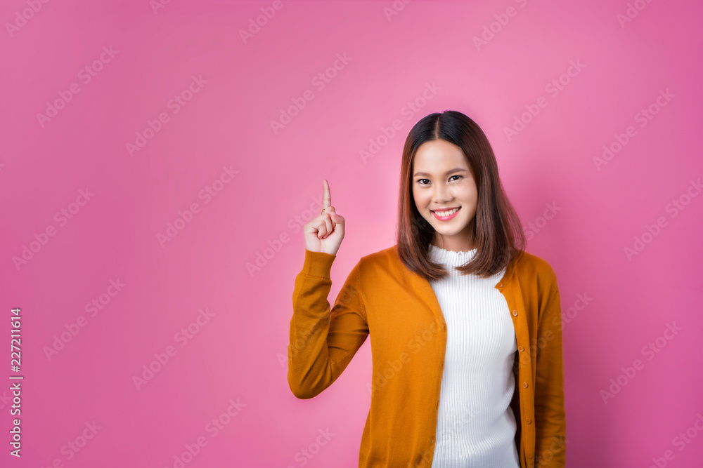asian woman pointing fingers on pink background asian woman pointing fingers on pink background