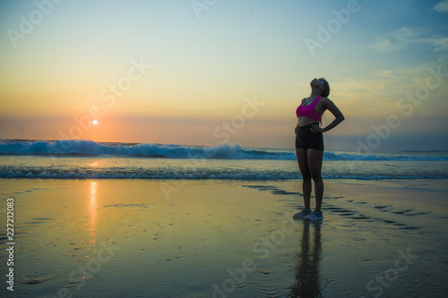 young sporty and tired African American runner woman cooling off breathing exhausted after running workout at beautiful beach sunset in healthy outdoors fitness