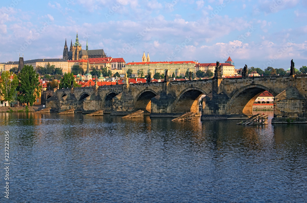 Fototapeta premium Scenic view on Vltava River and Charles bridge. Prague Castle with ancient Saint Vitus Cathedral at the background. Summer morning landscape photo. Prague, Czech Republic