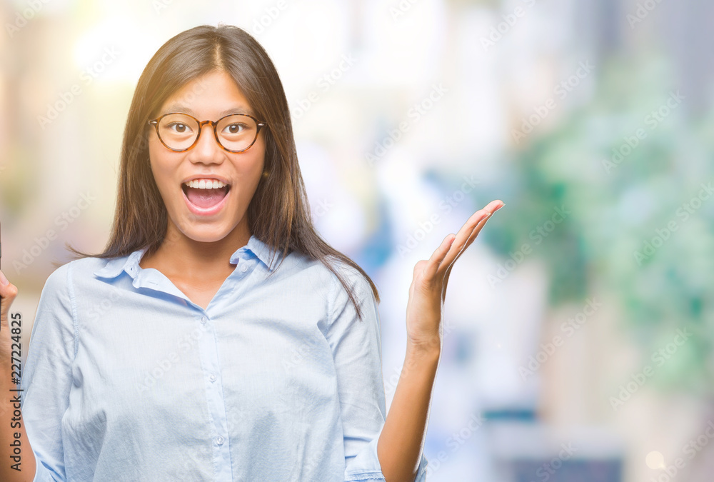 Young asian woman showing smartphone blank screen over isolated background very happy and excited, winner expression celebrating victory screaming with big smile and raised hands Young asian woman showing smartphone blank screen over isolated background very happy and excited, winner expression celebrating victory screaming with big smile and raised hands