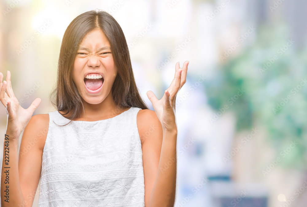 Young asian woman over isolated background crazy and mad shouting and yelling with aggressive expression and arms raised. Frustration concept. Young asian woman over isolated background crazy and mad shouting and yelling with aggressive expression and arms raised. Frustration concept.