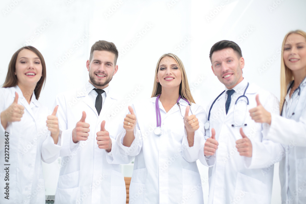 Portrait of a doctor and medical team showing thumb up Portrait of a doctor and medical team showing thumb up