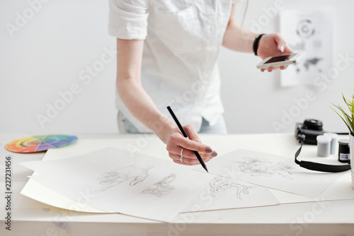 Young female designer creating sketches and infographics