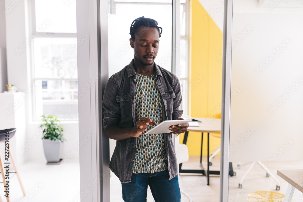 afro-american man standing in flat with tablet afro-american man standing in flat with tablet