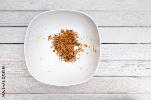 Pouring brown sugar into mixing bowl with ingredients for making cookies